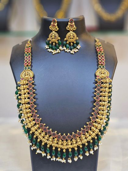 This long temple haar with green and red stones and green beads is a statement piece on its own.