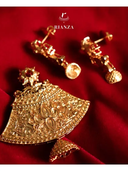 An example of gold embossing work in a temple jewellery pendant and earring set. The detailed floral motifs give a new dimension to traditional ethnic wear.