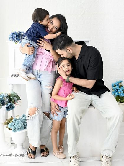 A candid and joyful family of four. This photo is filled with hugs, kisses, and laughter, perfectly capturing the chaotic and beautiful reality of family love.