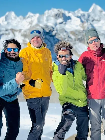 The sheer joy and relief after a tough climb on the Pin Parvati expedition. The smiles are as bright as the snow.