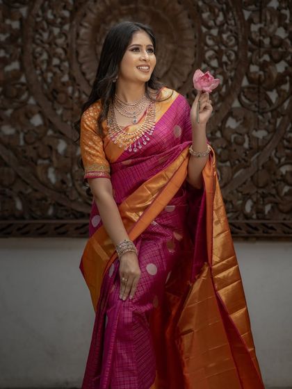 A full-length view of the pink and orange saree, its bright colors a perfect choice for a festive occasion.