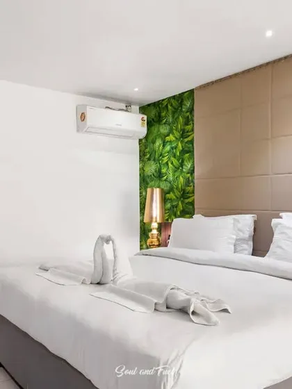 Another angle of the hotel room, showing the balance between the bold green wall and the neutral, calming elements of the space.