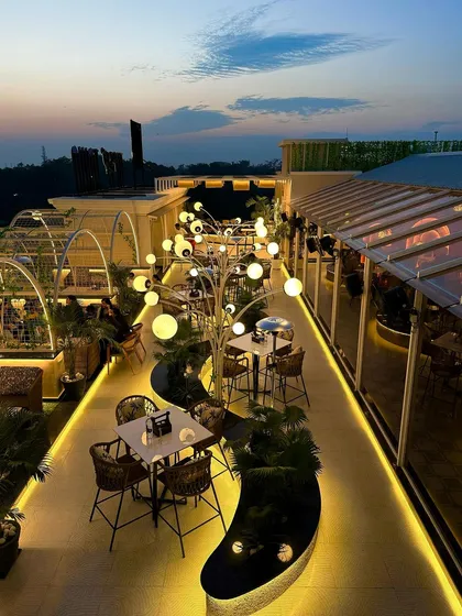 A view of the completed Tipsy Town rooftop in Ayodhya. My goal was to create an organic, flowing space where sculptural lighting and lush greenery guide you through different zones, making the entire rooftop feel like an enchanted garden.