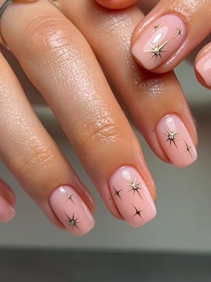 Simple yet magical, this design features tiny starbursts on a sheer pink base. It's a minimalist way to add a bit of sparkle and whimsy to your nails.