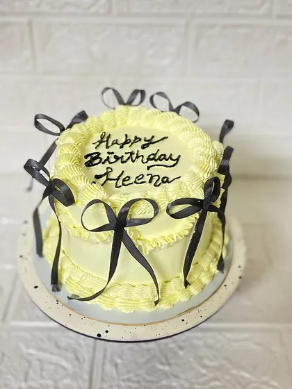 A clean, bright shot of the yellow and black bow cake.