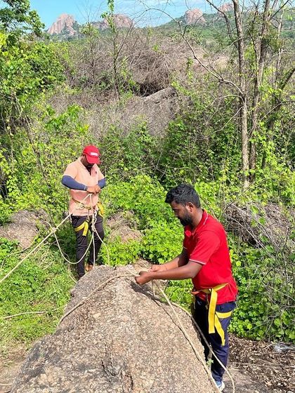 Two climbers work together to set up a safe and redundant anchor system.