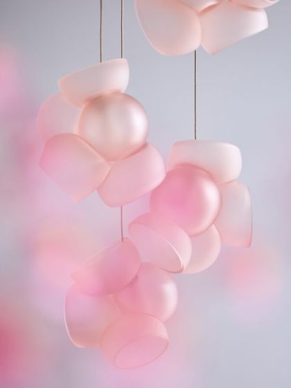 A dreamy, soft-focus shot of the pink Bocci 100 pendants, emphasizing their cloud-like appearance and gentle glow.