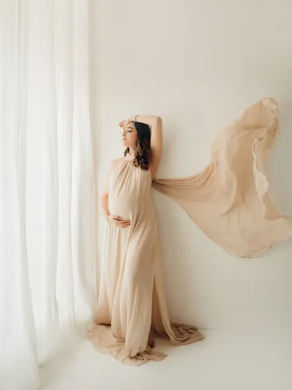 Every mother deserves to feel like a goddess. This shot, with the flowing fabric of a gown from my client wardrobe, captures the power and grace of pregnancy. We use natural light and simple props to create fine art maternity portraits like this.