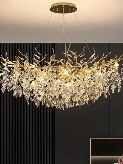 A large, branch-like chandelier with cascading crystals, creating a dramatic and luxurious statement piece for a high-ceilinged room.