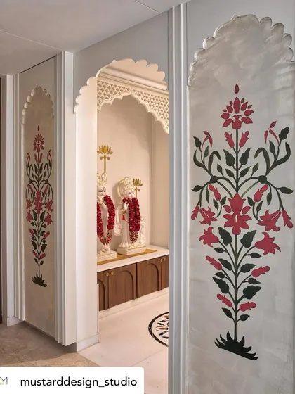 For this home's prayer space, I painted traditional floral motifs inspired by Mughal art. The symmetrical designs, rendered in rich red and green, frame the entrance to the mandir, creating a sense of handcrafted elegance and spiritual tranquility.