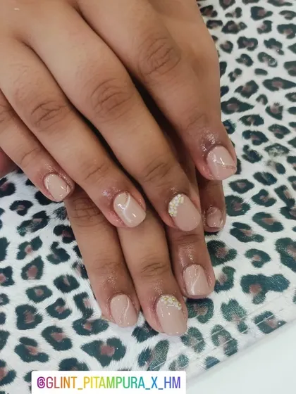 Subtle elegance with a touch of detail. These short, natural-looking nails feature a nude base with delicate white marble-effect lines and a single accent nail adorned with tiny pearls for a refined finish.