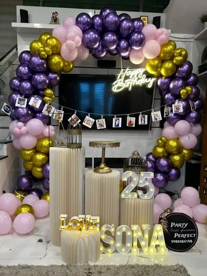 This 25th birthday setup shows how I can personalize milestone events. It features a circular balloon arch in purple, pink, and gold, a 'Happy Birthday' neon sign, light-up '25', and a custom photo banner with your favorite memories.