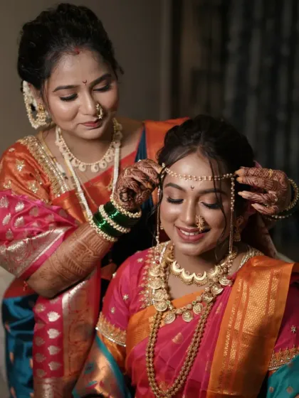 A touching moment between the bride and her mother or sister, adjusting the mundavalya.