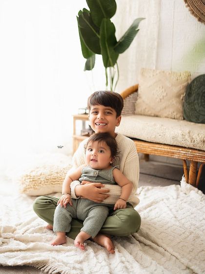 Big brother holding his baby sibling, a sweet and protective moment.