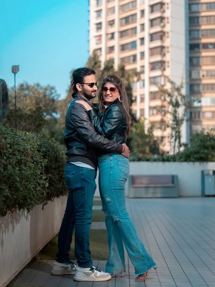 A casual and cool pre-wedding portrait in an urban park setting. The leather jackets and jeans give this shoot a modern, relaxed, and stylish vibe.