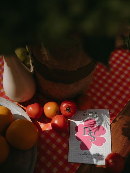 A rustic-chic detail from the carnival Mehendi, with fresh tomatoes and oranges on a gingham tablecloth, adding to the market-fresh, colorful vibe.