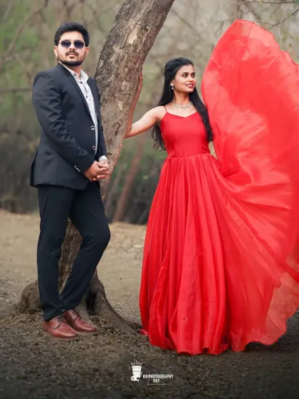 A playful moment in the woods. The flowing fabric of the red gown adds a sense of fun and movement to this pre-wedding shot.