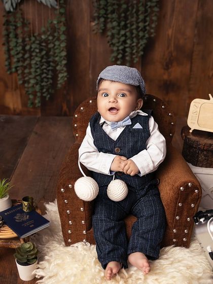 A happy little traveler, ready for an adventure. The props in this sitter session, like the tiny passport and vintage TV, add a fun, storytelling element to the photos.