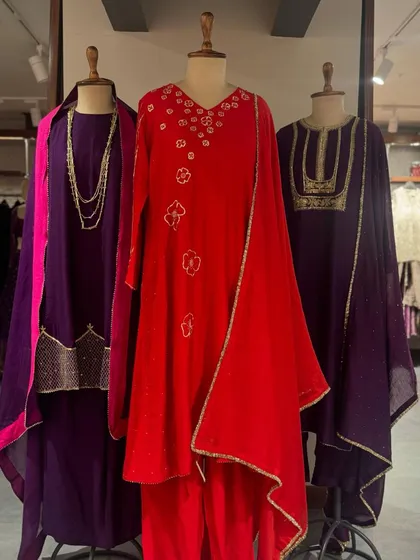 A full view of the purple and red collection, showing the flowing silhouettes and rich fabrics that are perfect for making a statement.