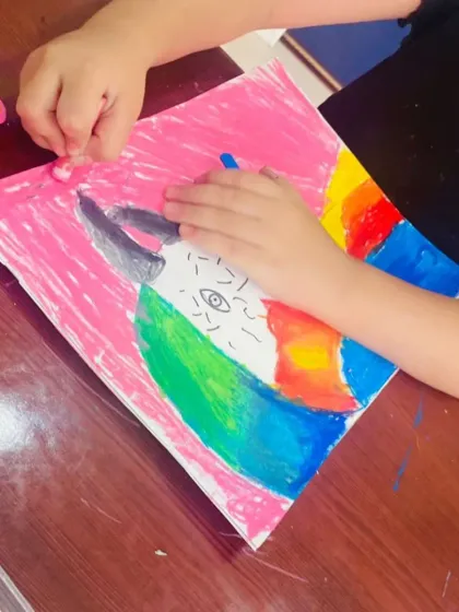 Here is a close-up of the oil pastel work on a macaw drawing. You can see how we layer colors like green, blue, and yellow to give the bird's feathers a rich, multi-toned effect.