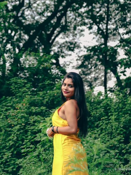 A wider shot that shows more of the beautiful green park setting, creating a classic lifestyle portrait.