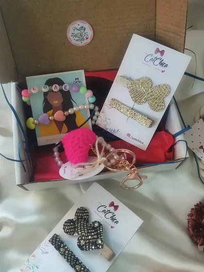 This 'Love Hamper' is the perfect gift for your best friend or sister. It comes with a personalized bracelet, a heart keyring, and a set of two chic hair clips in gold or black.