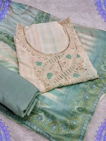 A soft sea-green dress material with delicate sequin work on the neckline. The matching dupatta has a subtle striped pattern, making it a very soothing and elegant set.