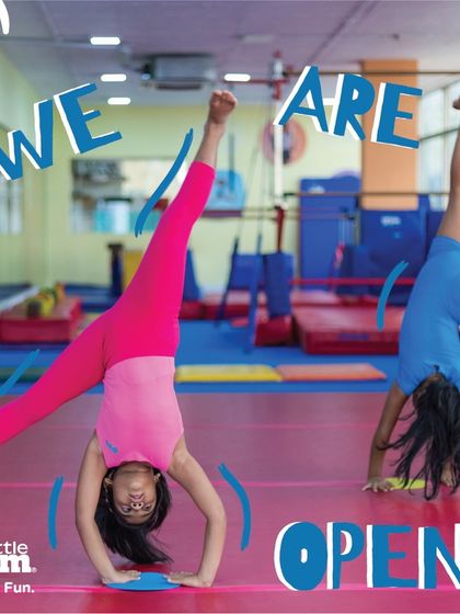 We are open. This vibrant image of two gymnasts mid-cartwheel perfectly captures the energy and excitement you will find at The Little Gym. Our space is ready for your child's next adventure.