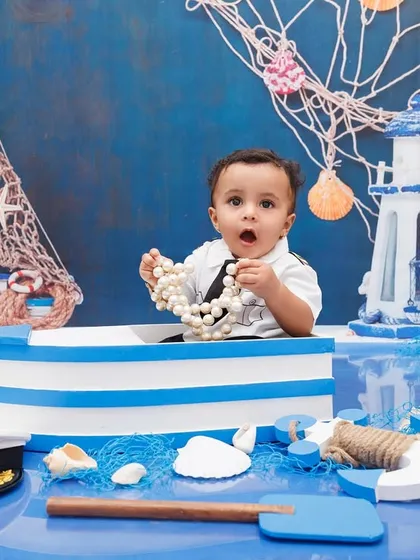A one-year-old boy discovers a string of pearls in his boat during his fun, sea-themed photoshoot.
