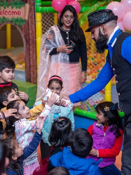 A magician entertains the children at Nirali's Barbie-themed party, captivating them with tricks and a live dove.