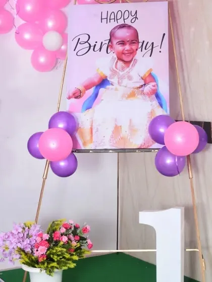 A personalized welcome portrait of the birthday girl, displayed on an easel and decorated with balloons, greeting guests as they arrive.