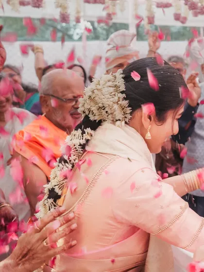 A beautiful candid of the bride dancing, enveloped in a shower of flower petals. This action shot perfectly captures the festive spirit of an Indian wedding.