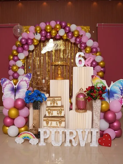 Another view of the glamorous butterfly theme, showing the full setup with pedestals and props. The combination of the shimmer wall and balloons is very effective.