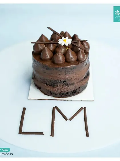 A classic Chocolate Truffle pastry, perfectly sized for one. It's topped with rich chocolate ganache kisses and decorated with our 'LM' initials in chocolate sticks.