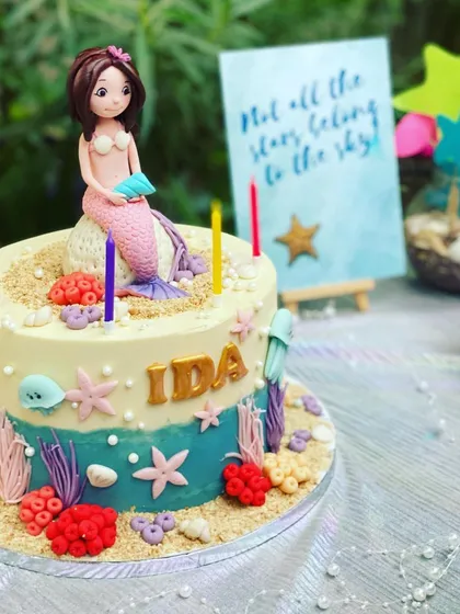 Every party needs a centerpiece, and this custom mermaid-themed cake is a perfect example of how I coordinate every detail. This beautiful cake features a mermaid topper, edible coral, and starfish to fit the under-the-sea adventure.