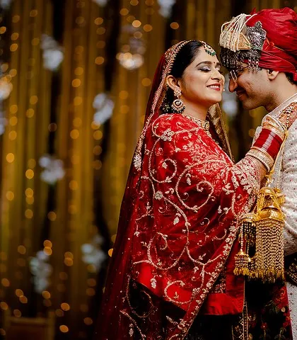 A romantic and playful moment from a wedding day. The bride's touch and the couple's smiles create a beautiful, candid feel.