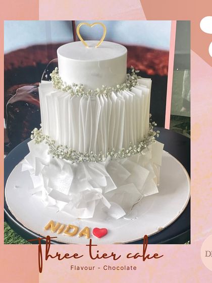 An elegant and modern three-tier cake featuring edible white paper ruffles and delicate baby's breath. This design showcases our expertise in using unique, fully edible materials for a sophisticated look.