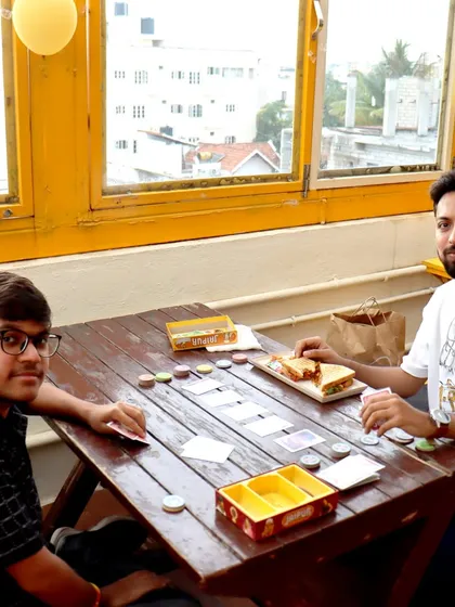 A game of 'Jaipur' being played over sandwiches. It's the perfect combination of a light meal and a light, fun game.