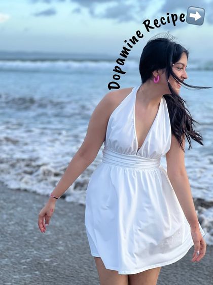 A happy moment on the beach. This white halter dress is a perfect, breezy option for a beach vacation.