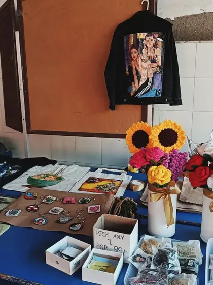 My table setup at the festival, displaying a variety of my work, from sketches and small prints to a custom-painted jacket.
