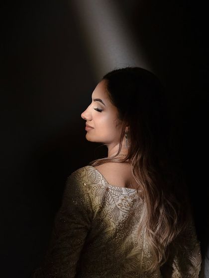 A dramatic shot of Maanvi, with light highlighting her soft makeup. This shows the artistic and photographic quality of the look.