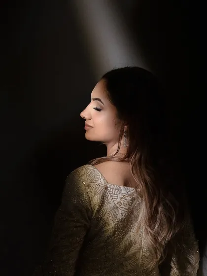 A dramatic shot of Maanvi, with light highlighting her soft makeup. This shows the artistic and photographic quality of the look.