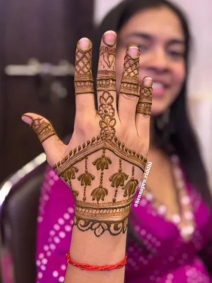 This is a perfect example of a minimal yet striking design for a bridesmaid or wedding guest. The hanging lotus motifs on the back of the hand are delicate and stylish.