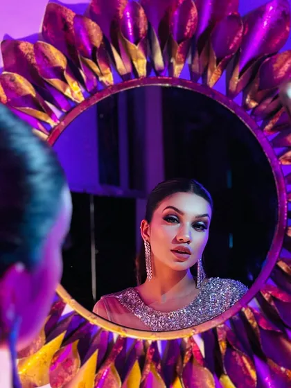 A creative shot using a mirror to reflect this glamorous look. The purple and gold lighting adds to the mood.
