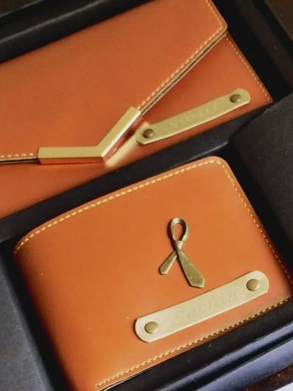 A close-up of the personalized couple's wallet set. The wallets are made from high-quality tan leatherette and can be customized with initials, names, and charms.