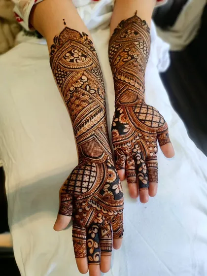This angle highlights the intricate patterns on the forearms, with repeating motifs that create a cohesive and grand design.