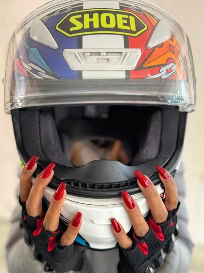 Who says you can't be chic while being a badass? This client proves that a fierce red manicure is the perfect accessory for any lifestyle, even a biker's. Style has no limits.