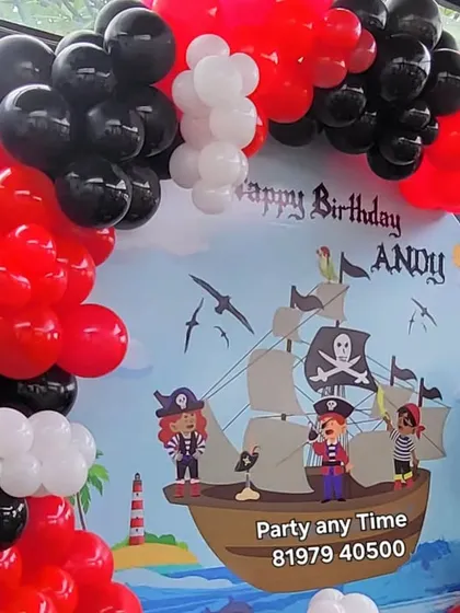 A closer look at the pirate ship backdrop and balloon arrangement. I use details like a skull and crossbones flag to make the theme authentic.