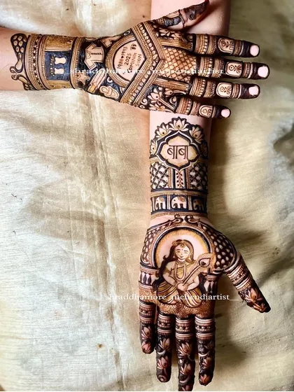 A special baby shower mehendi featuring a portrait of Bal Krishna (Ladoo Gopal) on the palm. The design also includes the word 'Baba' and a line of elephants, adding traditional and personal touches.