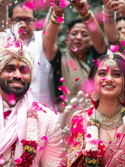 The bride's grand entrance, showered with love and petals by her family. This is a candid, emotional wedding day photo that captures the energy and support surrounding the couple.